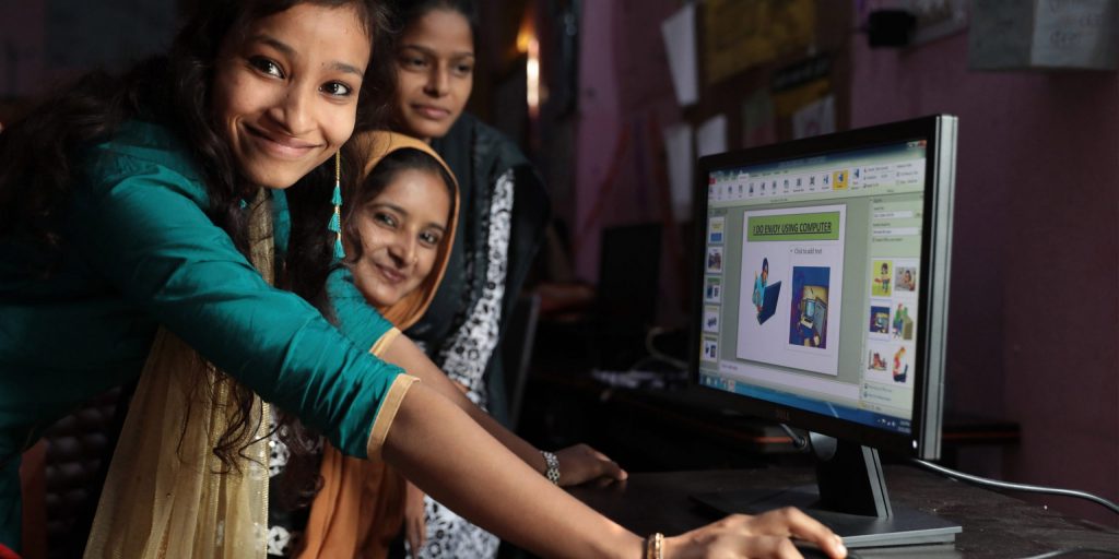 Participants in the Young Women Leadership Program explain software to each other