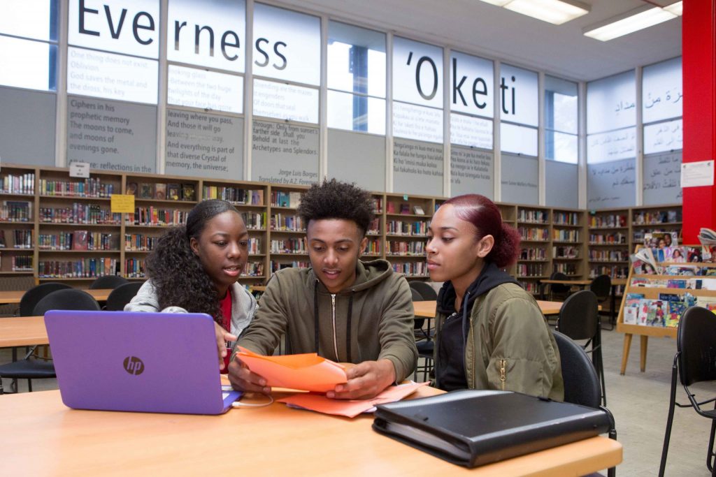 Two high school girls and a high school boy at a computer